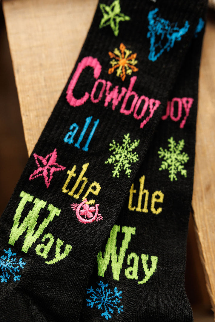Savannah Sevens western life{&}style Cowboy All The Way Crew Socks feature colorful text, stars, snowflakes, and a pink smiley face on black. Made from an odor-fighting hemp blend for comfort and style.
