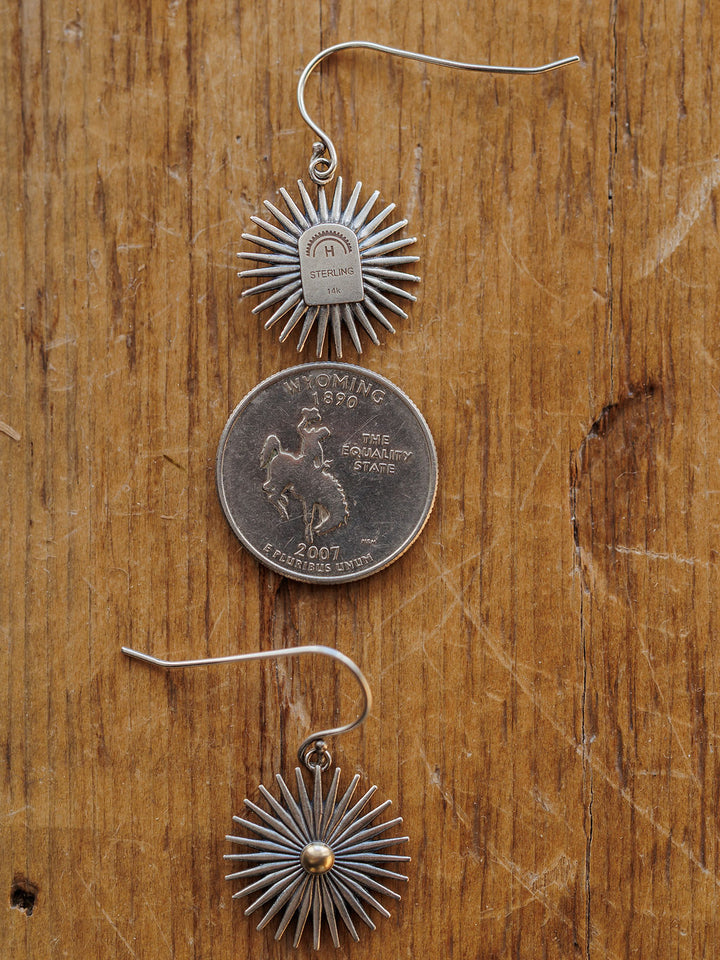 Two Rowel Earrings {Small} by Savannah Sevens western life{&}style rest on a wooden surface, one facing up, one down, with a Wyoming state quarter between them for size reference.
