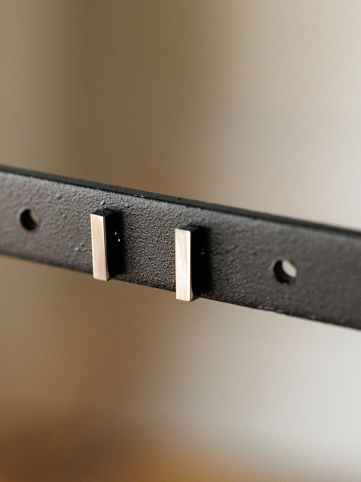 Close-up of the Lexington Earrings by Savannah Sevens western life{&}style—black metal bar studs featuring two rectangular silver pegs and three round holes, set against a blurred neutral background.