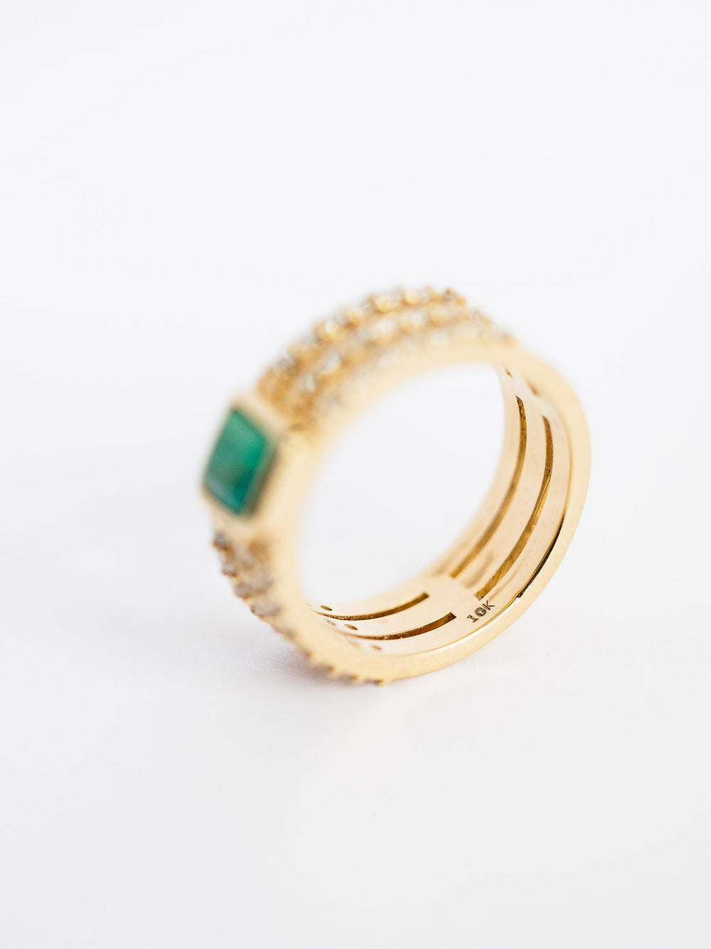 The Diamond Turquoise Ring by Savannah Sevens western life{&}style features a green rectangular gemstone and lab grown diamonds along a gold band, inspired by Southwest turquoise designs, shown against a white background. Collaboration the Devereaux Gold.