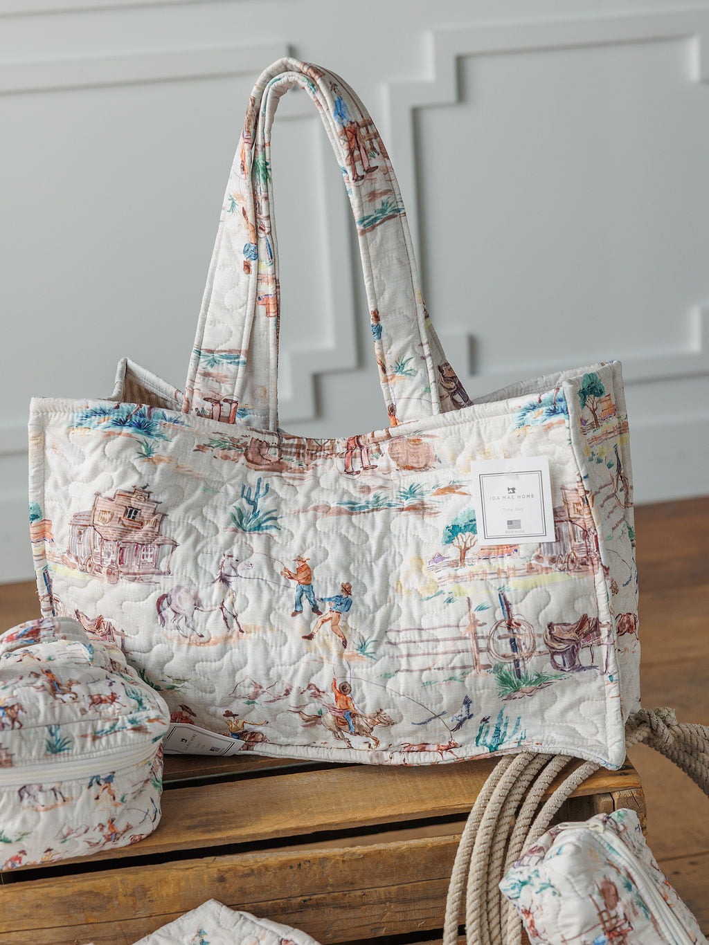 The Retro Cowboy Collection by Savannah Sevens western life{&}style features a handmade quilted tote with padded handles, colorful countryside illustrations, with matching pouches.