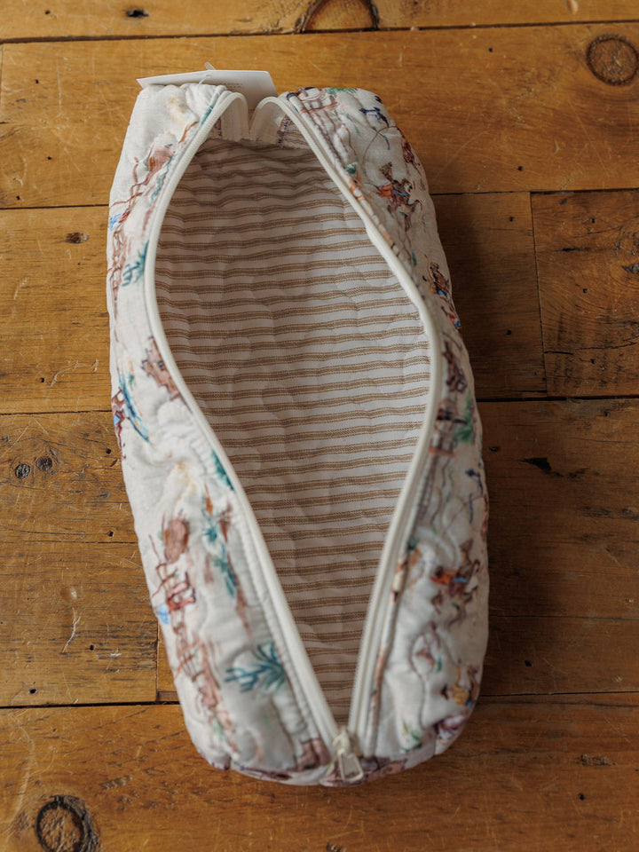 The Retro Cowboy Collection zippered pouch by Savannah Sevens western life{&}style features a handmade quilted design with a light striped lining and soft, subtly patterned exterior, shown open on wood.