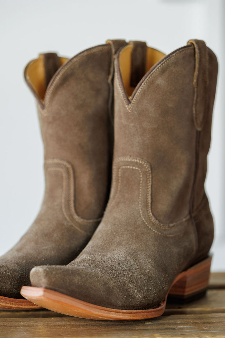 The Cordova by Savannah Sevens western life{&}style: brown rough out leather booties with snip toes, decorative stitching, and wooden heels, shown on a wooden surface. Made by Black Star. 