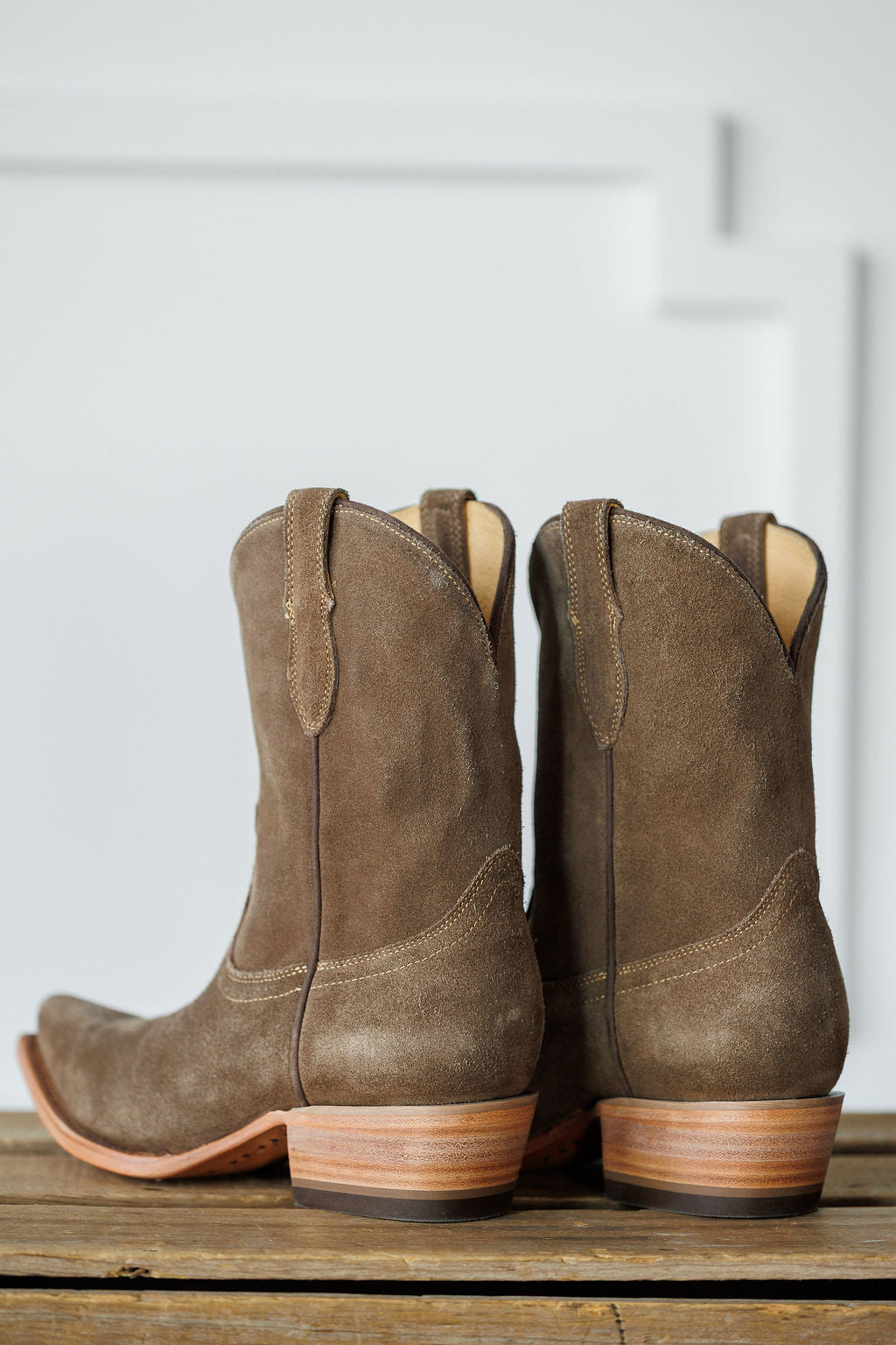 The Cordova booties by Savannah Sevens western life{&}style feature brown suede, snip toes, leather soles, and pull tabs, displayed on a wooden surface with a light background. Made by Black Star. 