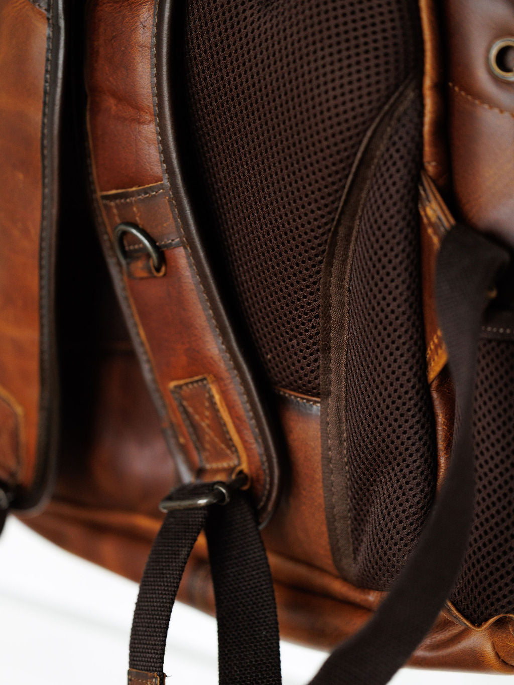 Close-up of the Waynesboro Backpack by Savannah Sevens western life{&}style, featuring full grain leather, padded mesh back panel, adjustable shoulder straps with metal hardware, and detailed stitching.