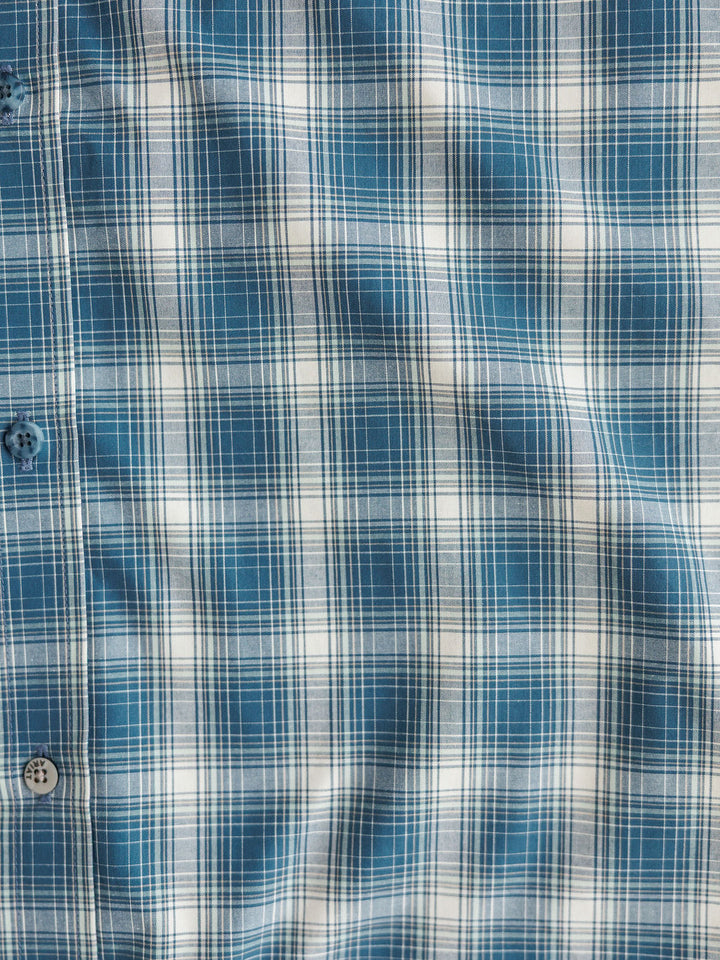 Close-up of The Davis {Men's} by Savannah Sevens western life{&}style—a blue and white plaid, moisture-wicking long sleeve shirt with a button-down design and visible blue buttons on the left side.