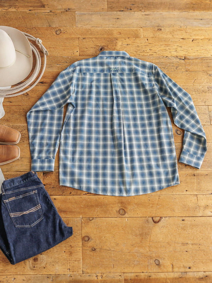 The Davis {Men’s} plaid long sleeve shirt by Savannah Sevens western life{&}style, featuring sun protection, is laid flat and back-facing on a wooden floor with folded blue jeans, brown boots, a coiled rope, and a white cowboy hat.