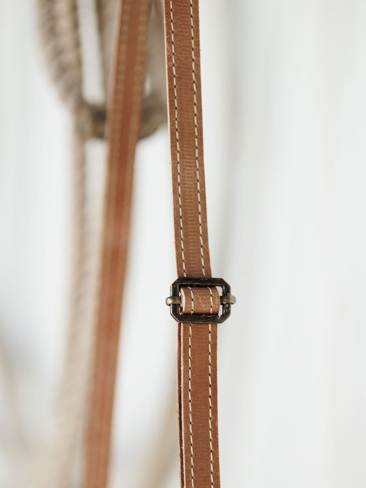 Close-up of The Lomita by Savannah Sevens western life{&}style—a brown leather strap with white stitching and a small metal buckle, perfect for accenting your favorite crossbody bag.