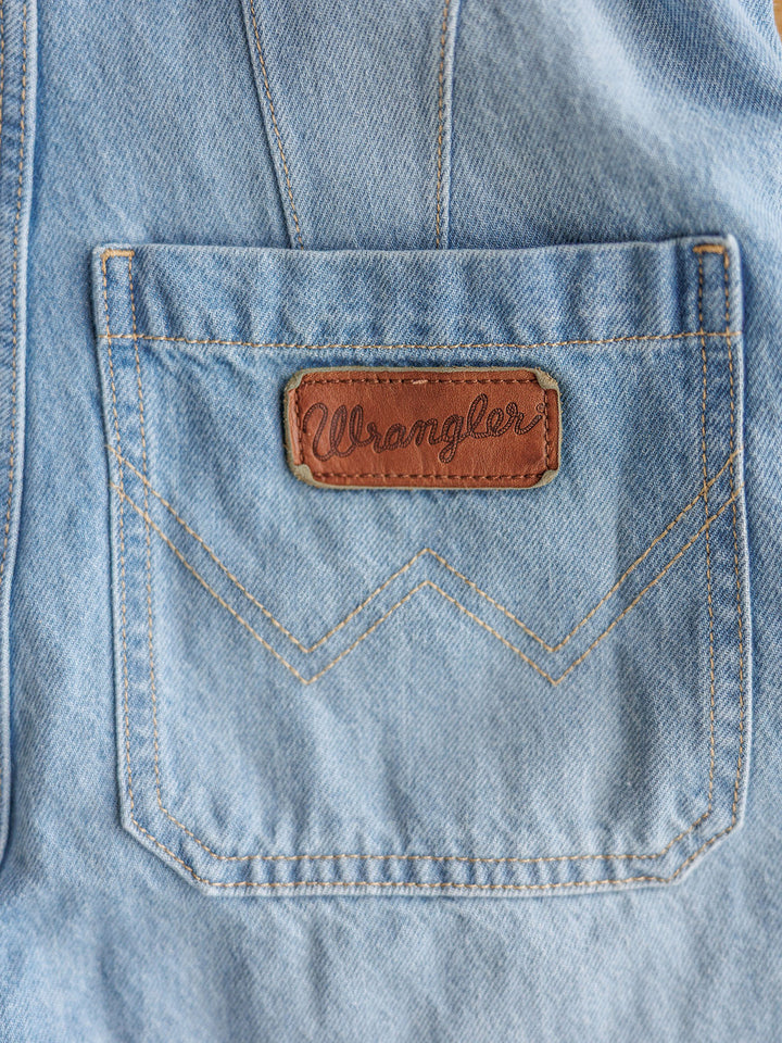 Close-up of The Kennard by Savannah Sevens western life{&}style: medium light wash denim with a brown leather patch above the pocket. Yellowish double V stitching adds unique detail to the classic western design.