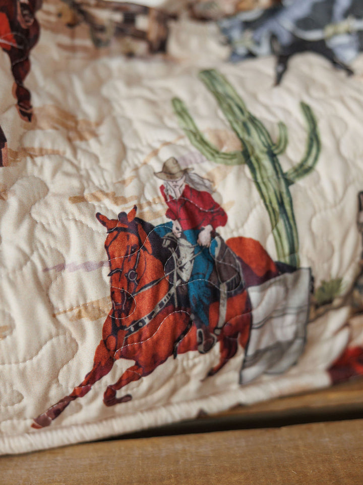 Cowgirl Gingham Collection by Savannah Sevens western life&style features quilted fabric inspired by western bags, with a cowboy in a red shirt and hat riding a brown horse beside a large green cactus.