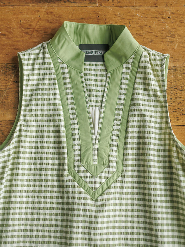 The Halstad by Savannah Sevens western life{&}style is a sleeveless green and white patterned blouse with a stand-up collar, V-neckline, and green trim, shown laid flat on a wooden surface.