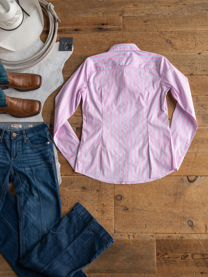 The Kinnear by Savannah Sevens western life{&}style, a wrinkle-resistant pink and white striped long sleeve top, is styled flat with blue jeans, brown cowboy boots, a white cowboy hat, and a coiled rope on a wooden floor.