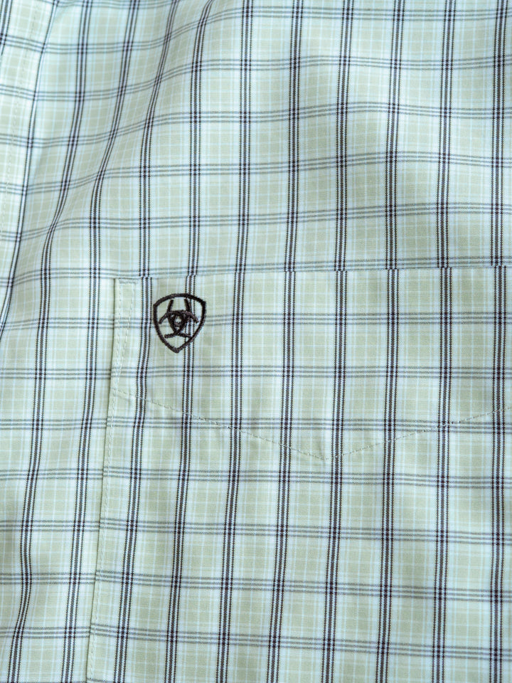 Close-up of The Graham men's plaid shirt in light green and blue by Savannah Sevens western life{&}style, with a small black embroidered logo above the chest pocket. This short sleeve button-up is wrinkle free for easy care and style.