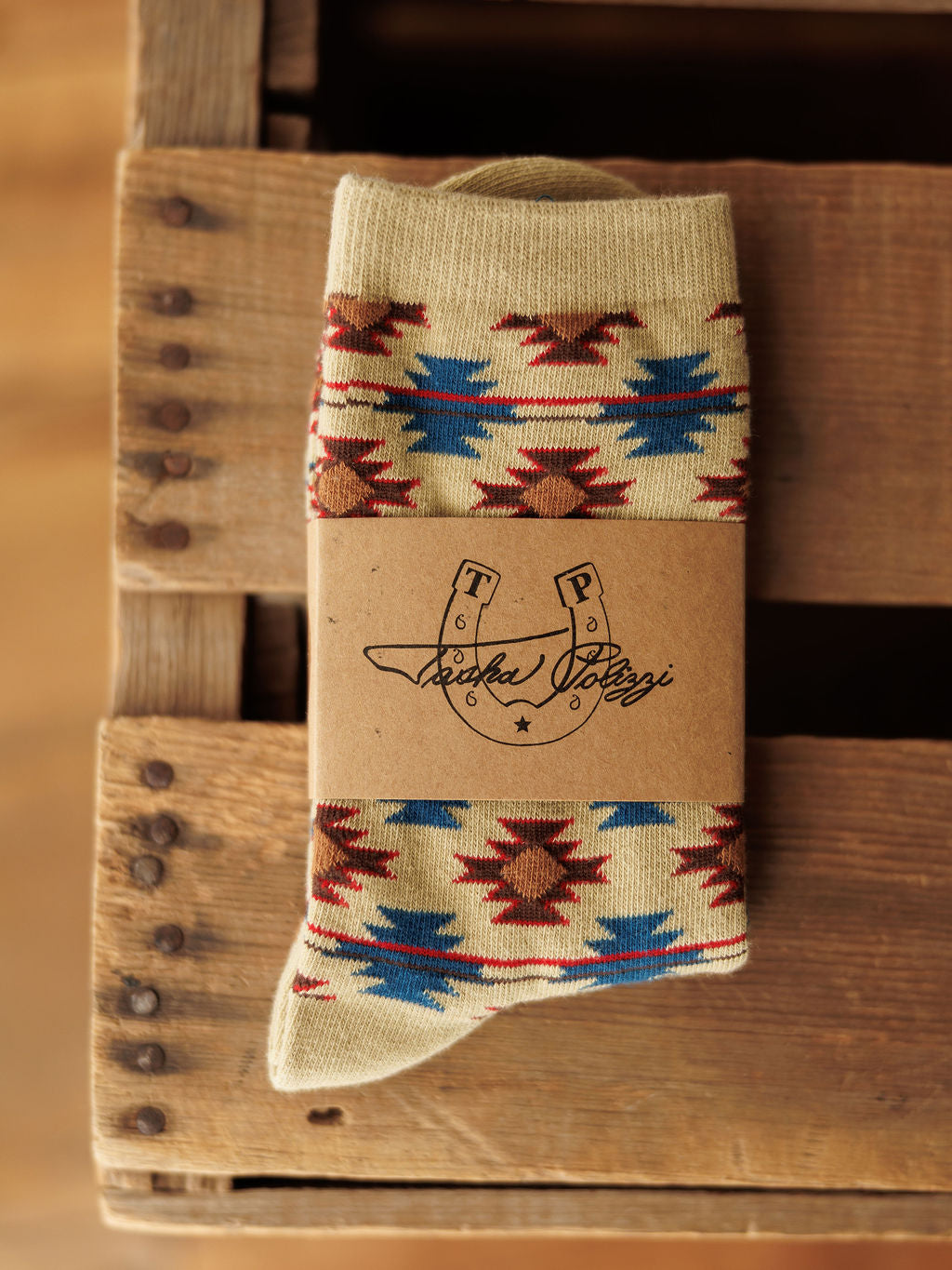 The Rio Crew Socks by Savannah Sevens western life{&}style feature red, blue, and brown star designs and come wrapped in a brown paper label with the Tasha Polizzi horseshoe logo. Stylish women’s socks for any outfit.