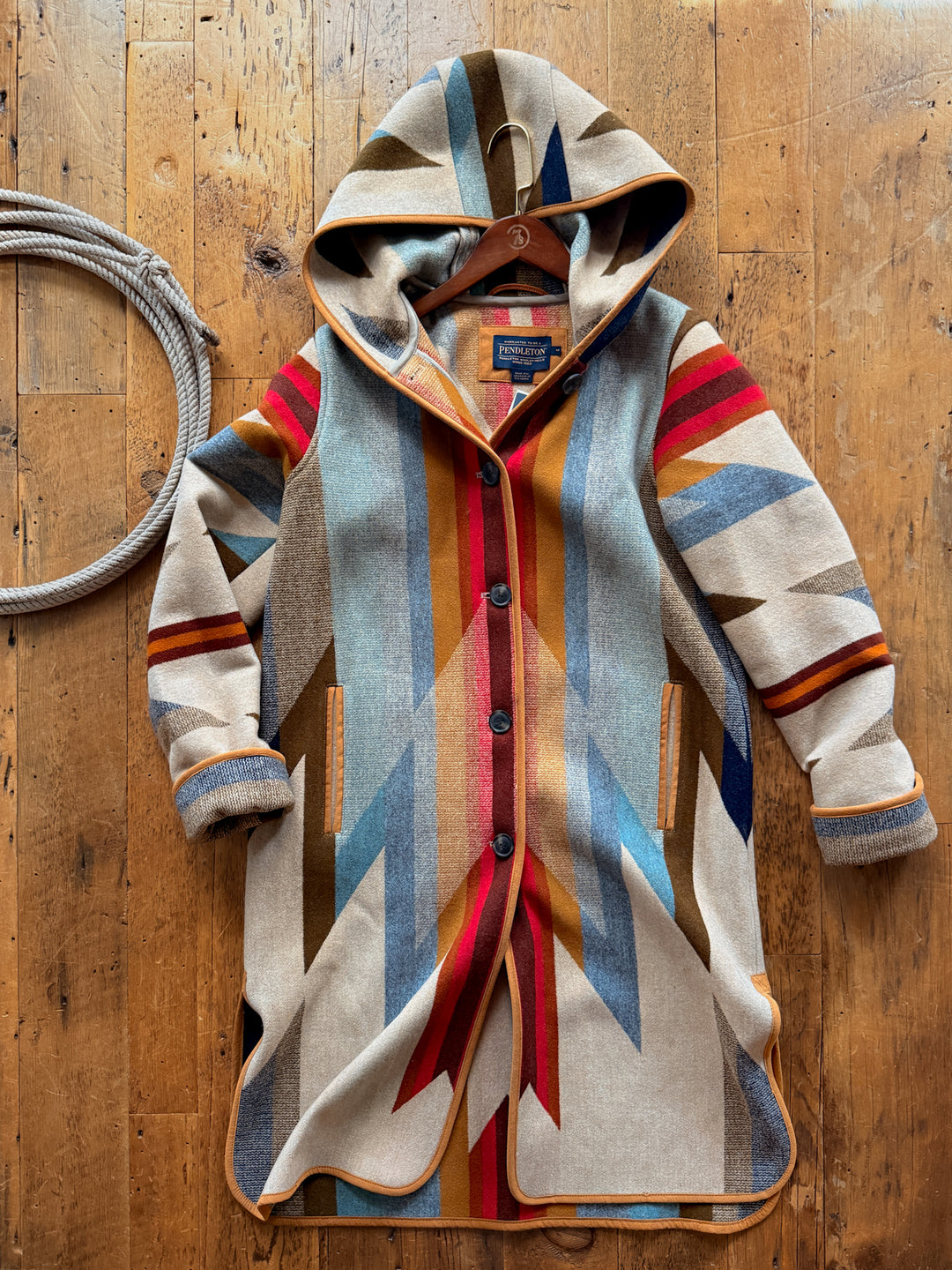Wyeth Trail Pendleton Long Coat in virgin wool, featuring a long-sleeved, hooded southwest design with a colorful geometric pattern and button front closure.
