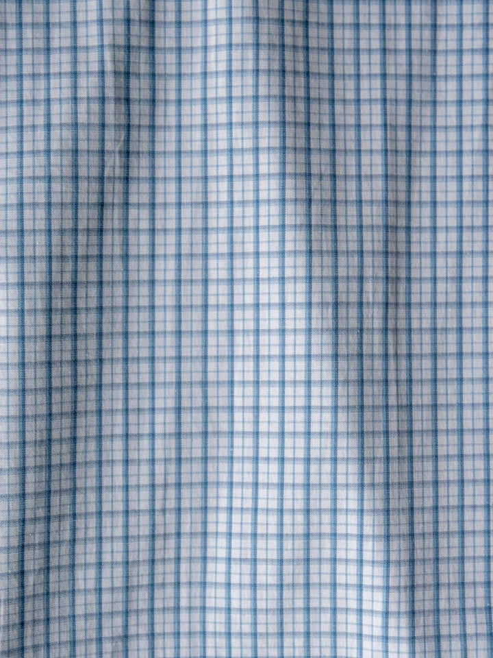 Close-up of the soft, slightly wrinkled blue plaid fabric on the Bentonville Wrangler Men's Blue Plaid Button Up by Savannah Sevens western life{&}style. Features a light blue and white checkered grid pattern.