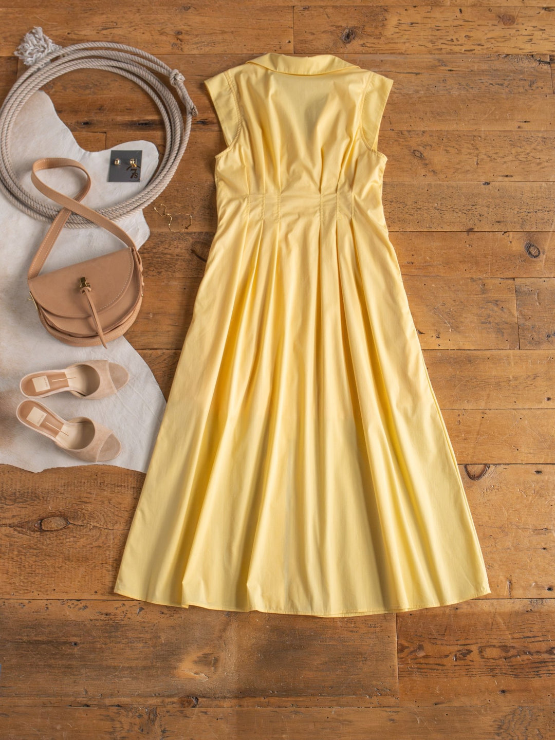 The Biloxi Butter Zip Front Dress by Savannah Sevens western life{&}style is displayed on a wooden floor with beige flats, a tan crossbody bag, and gold earrings.
