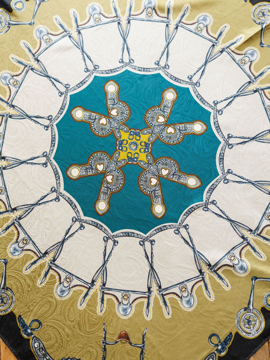 The Bits Wild Rag {Teal} by Savannah Sevens western life{&}style is a vibrant jacquard silk scarf with scissors and ornate keys in a kaleidoscopic paisley design, featuring teal, white, and gold for a luxurious statement.