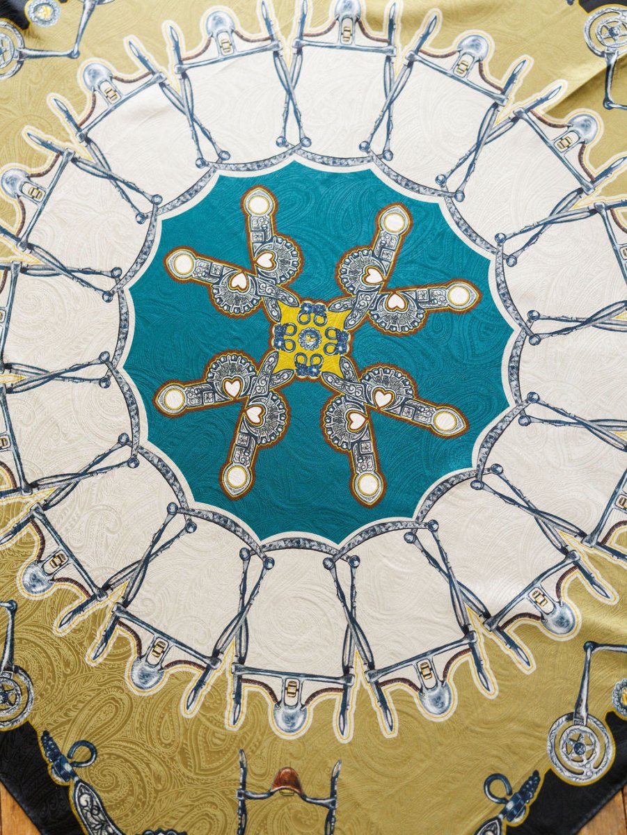 The Bits Wild Rag {Teal} by Savannah Sevens western life{&}style is a vibrant jacquard silk scarf with scissors and ornate keys in a kaleidoscopic paisley design, featuring teal, white, and gold for a luxurious statement.