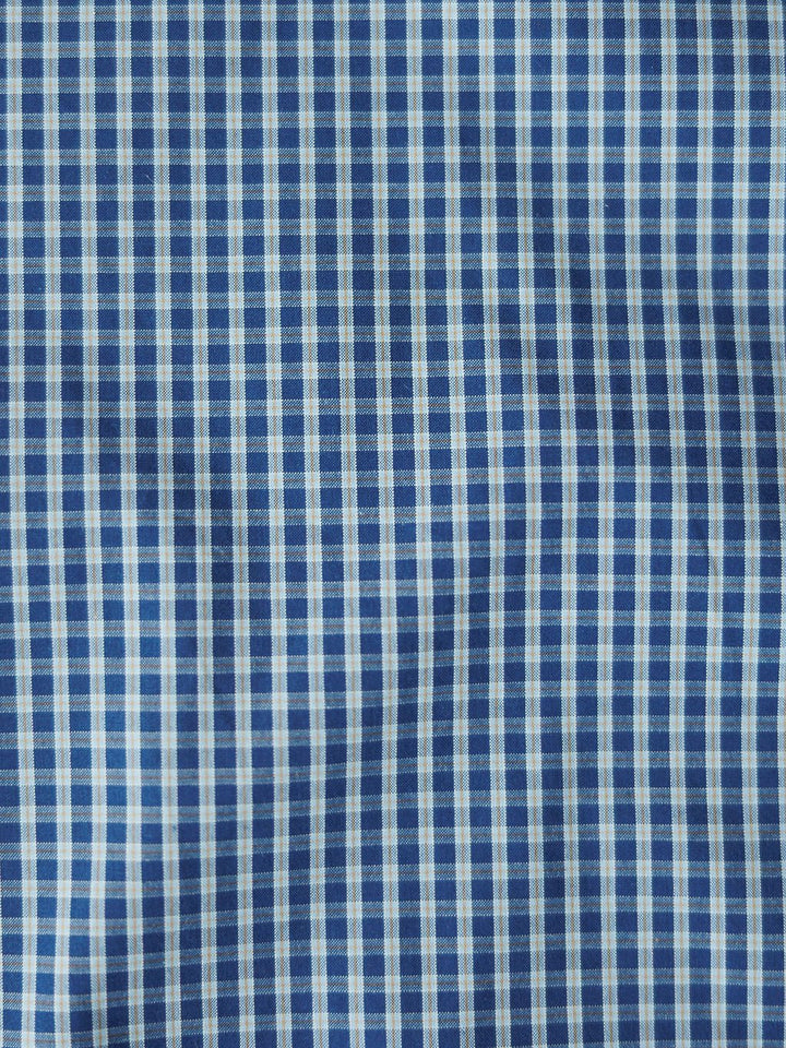 Close-up of blue and white checkered fabric shows the textured grid pattern and wrinkles of the Brentwood Ariat Men's Blue Plaid Pearl Snap shirt by Savannah Sevens western life{&}style, featuring classic vertical and horizontal lines.