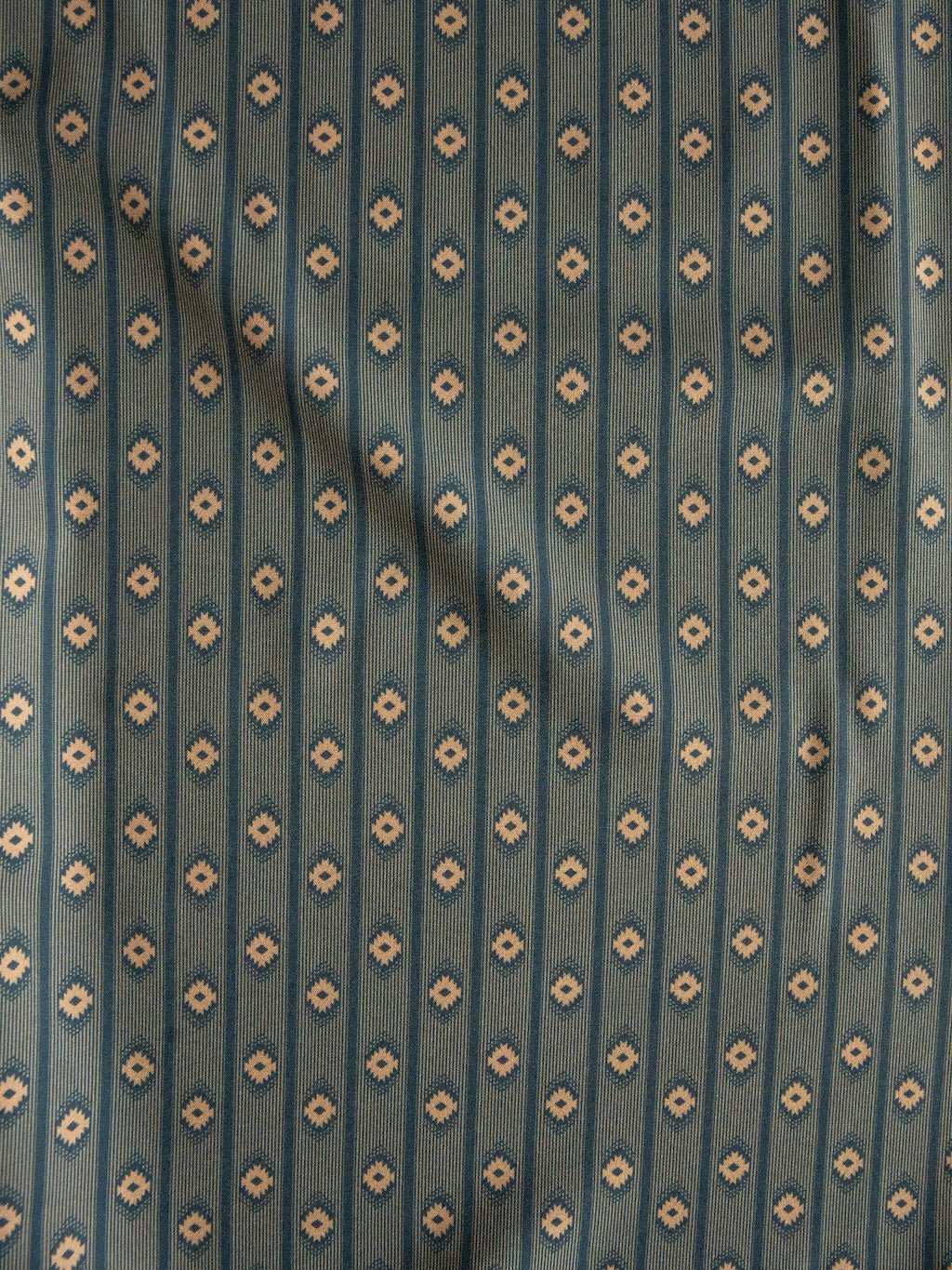 A blue-green fabric with a vertical stripe pattern of small beige floral motifs, subtly wrinkled and shaded as if gently draped—echoing the classic style of the Brigham Wrangler Men's Southwest Button Up by Savannah Sevens western life{&}style.