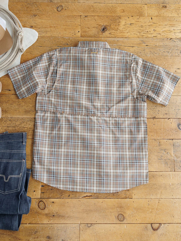 The Brimson Ariat Men's Plaid Button Up from Savannah Sevens western life{&}style in beige, brown, and blue is laid flat on a wooden floor with a straw hat and folded jeans nearby, blending style with moisture-wicking comfort.