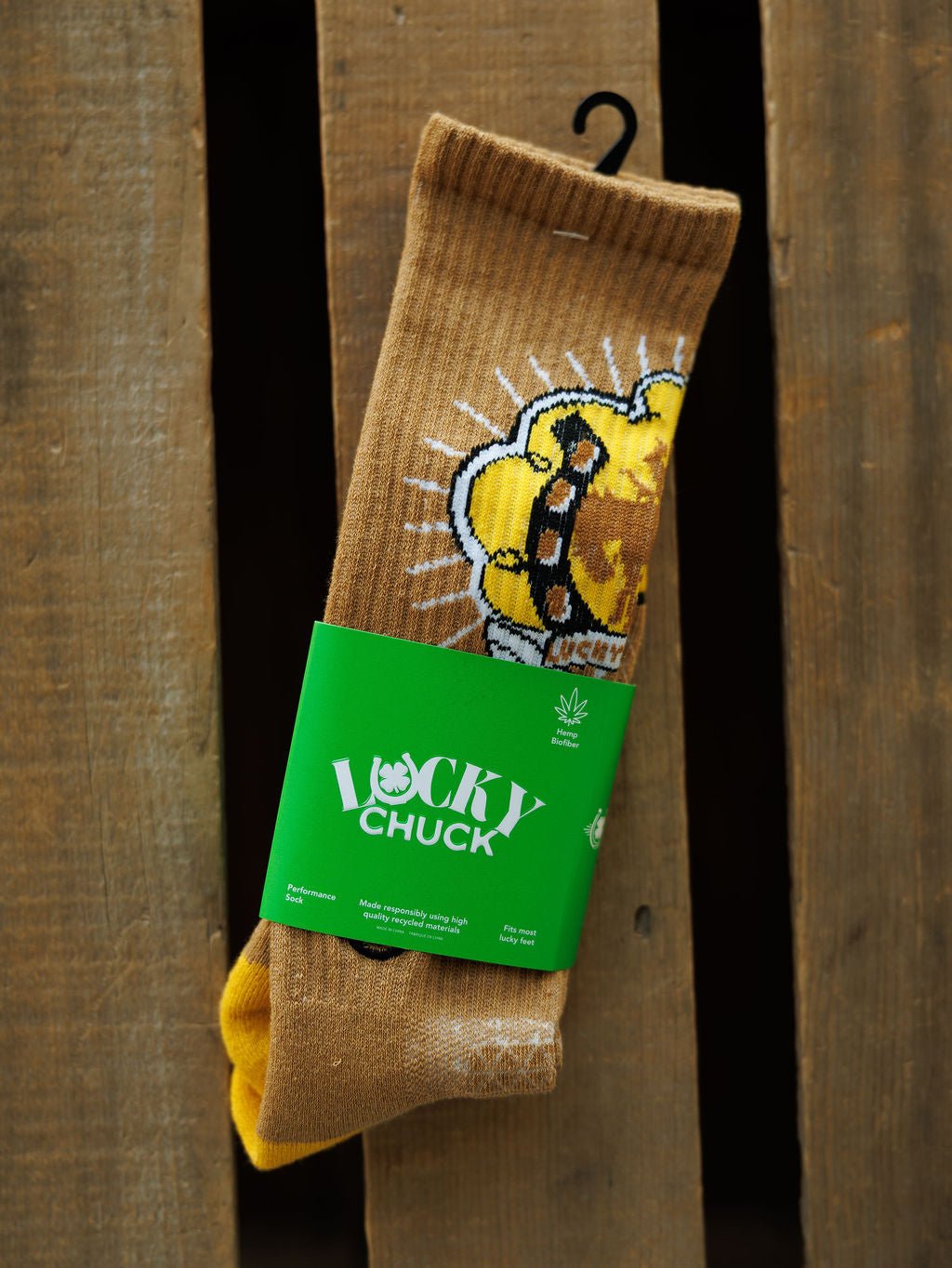 A pair of Bucking Cowgirl Crew Socks by Savannah Sevens western life{&}style, featuring a cartoon lion design and green Lucky Chuck label, shown on a wooden surface.