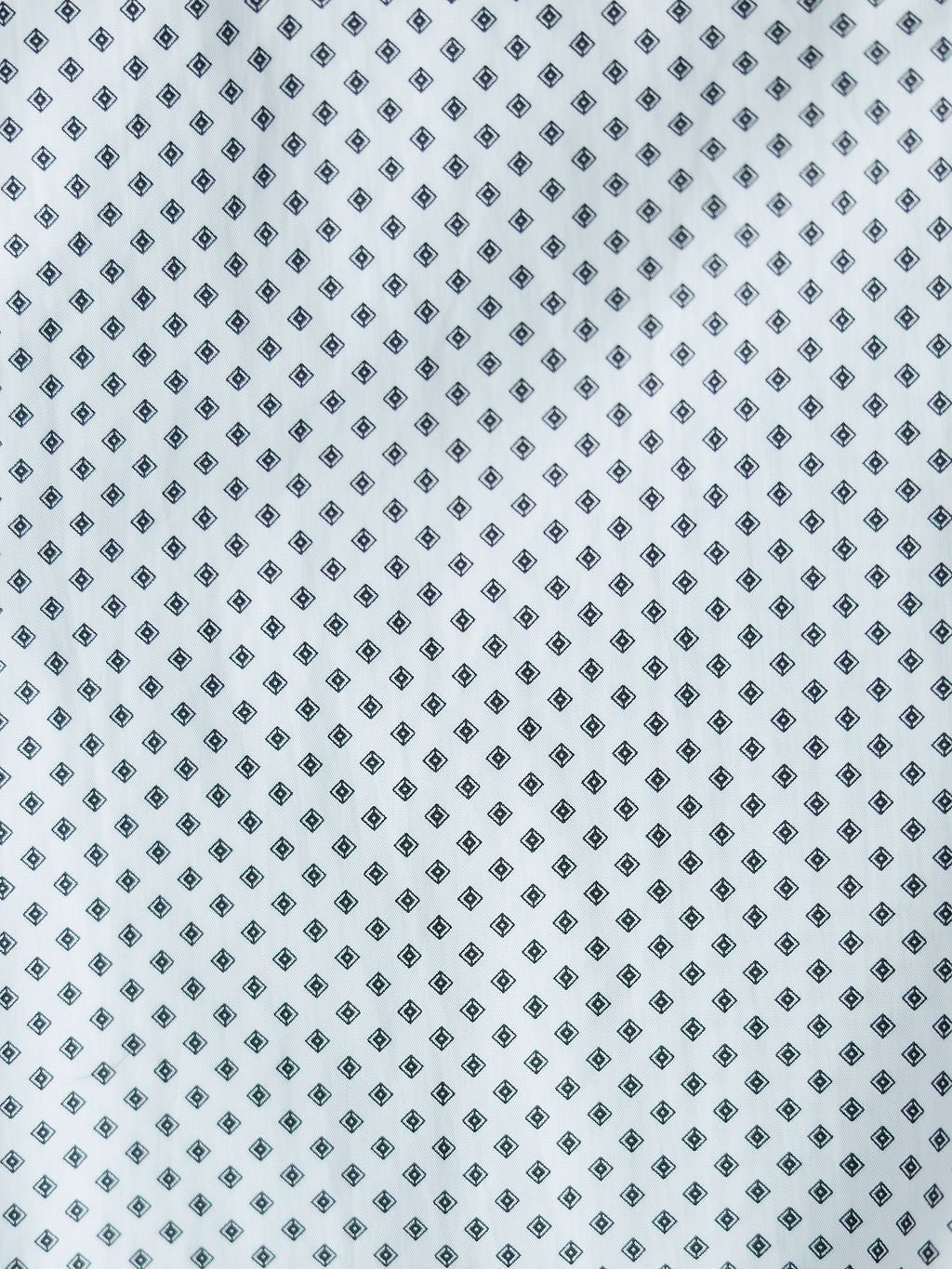 The Burke Ariat Men's Southwest Pearl Snap from Savannah Sevens western life{&}style features white fabric with a repeating small black diamond pattern, perfect for a classic, stylish men's snap button shirt.