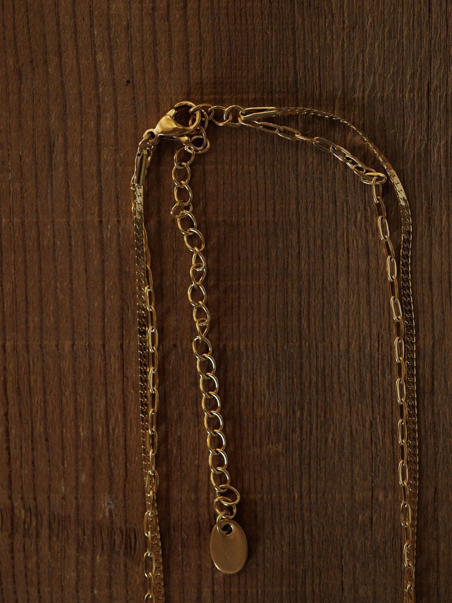 The Chenoa Necklace by Savannah Sevens western life{&}style is an 18K gold filled, hypoallergenic choker with an adjustable clasp and small oval pendant, shown on a textured wooden surface.