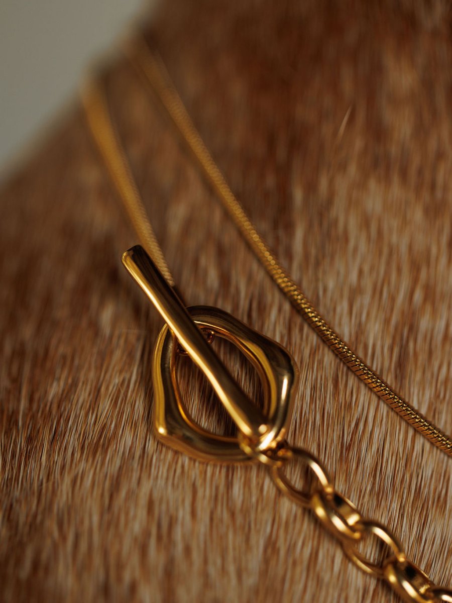 Close-up of the Cheraw Necklace by Savannah Sevens western life{&}style, featuring a gold filled toggle clasp, resting on a short, brown fur-textured surface.