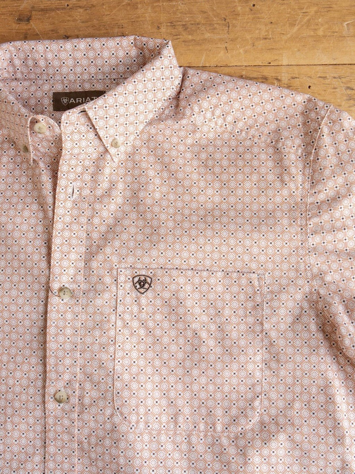 Savannah Sevens western life{&}style Copeland Ariat Men's Southwest Button Up shirt with short sleeves, a pocket, small embroidered logo, and ARIAT label, laid flat on a wooden surface.