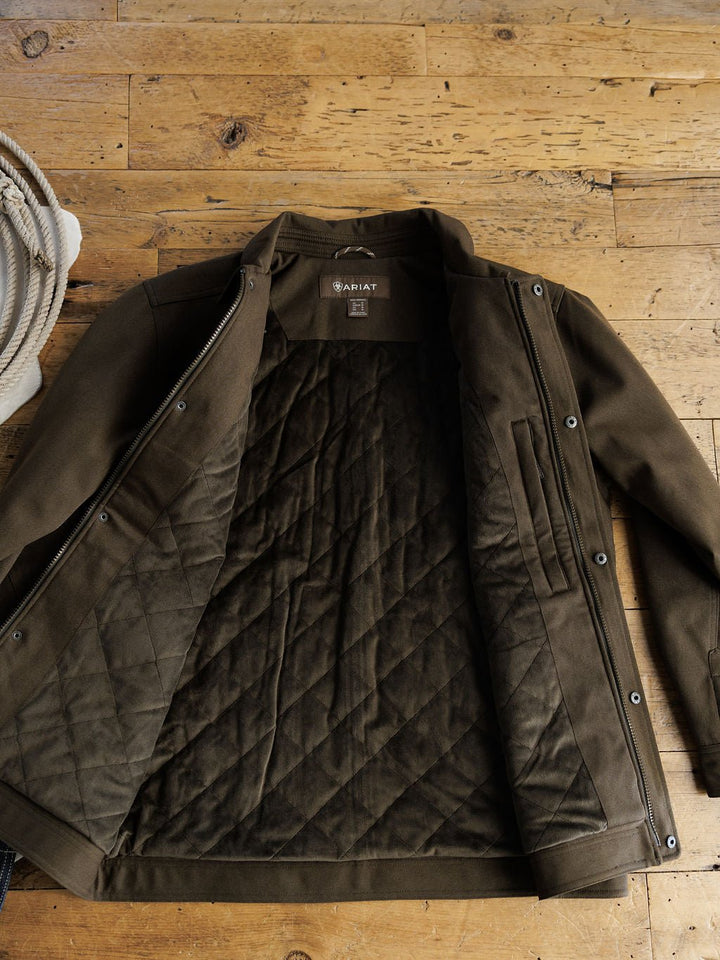 The Cornell Ariat Men's Insulated Jacket by Savannah Sevens western life{&}style lies open on a wooden floor, revealing its diamond-patterned lining, with a coiled rope partially visible in the top left corner.