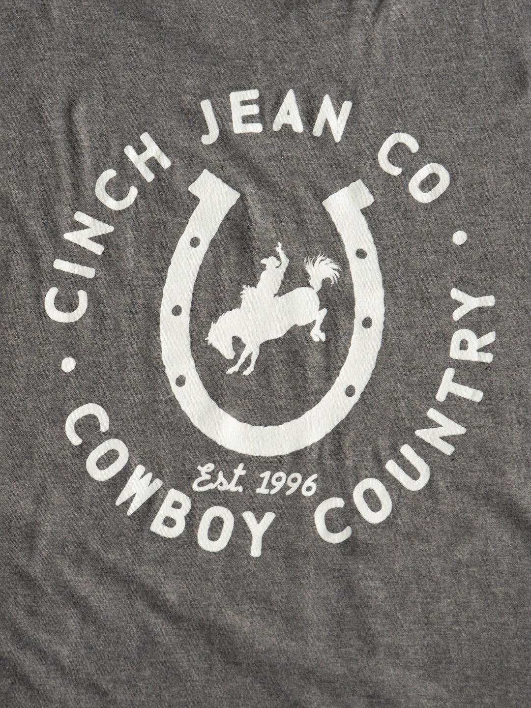 The Cowboy Country Men's Graphic Tee by Savannah Sevens western life{&}style features gray fabric, a white horseshoe, a cowboy on a bucking horse, and the text "COWBOY COUNTRY Est. 1996.