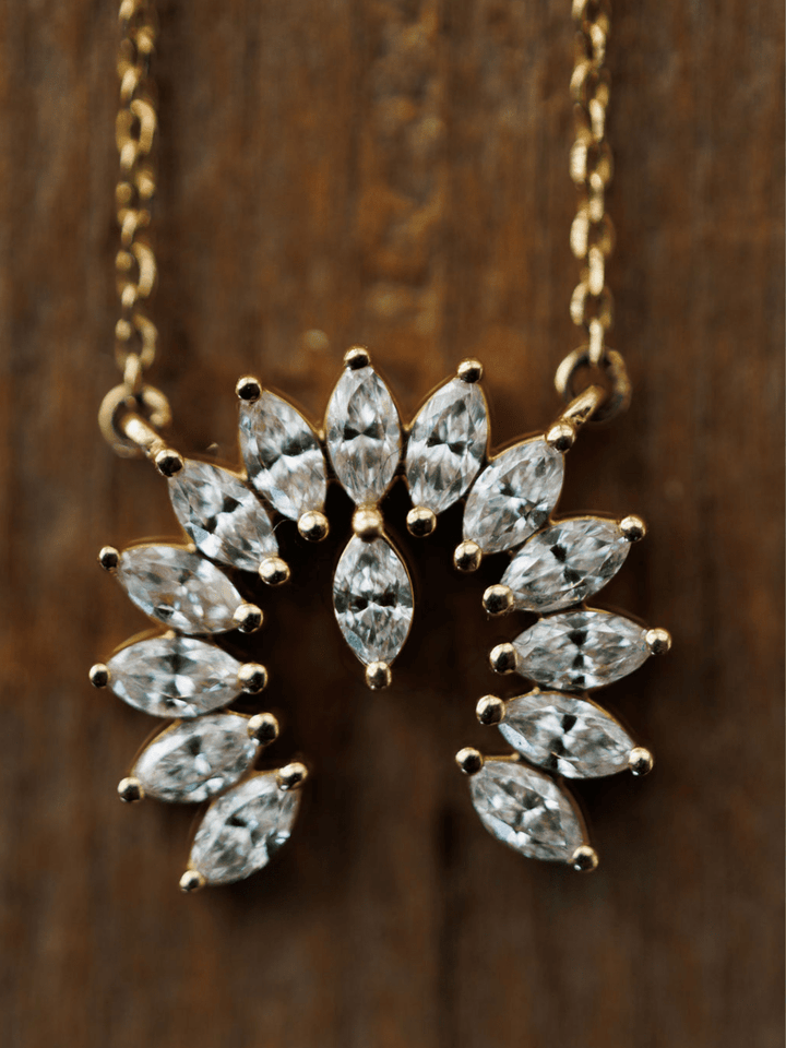 Savannah Sevens western life{&}style Diamond Naja Necklace: A 14K gold piece with a fan-shaped pendant set with marquise-cut lab-grown diamonds in a sunburst design, shown on rustic wood.