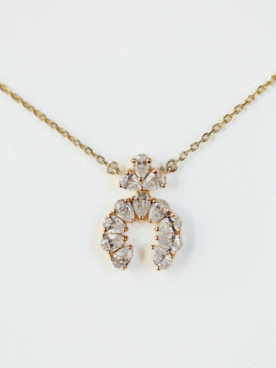 The Diamond Squash Necklace by Savannah Sevens western life{&}style features a 14K gold chain with clear, pear-shaped diamonds in horseshoe and triangular designs, shown against a white background.