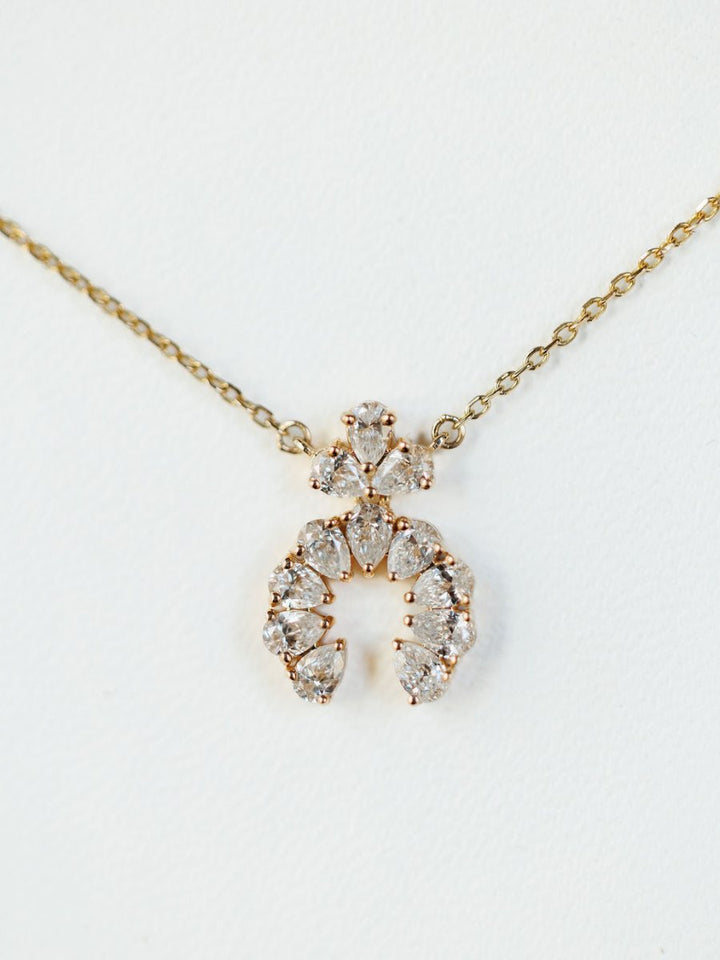 The Diamond Squash Necklace by Savannah Sevens western life{&}style features a 14K gold chain with clear, pear-shaped diamonds in horseshoe and triangular designs, shown against a white background.
