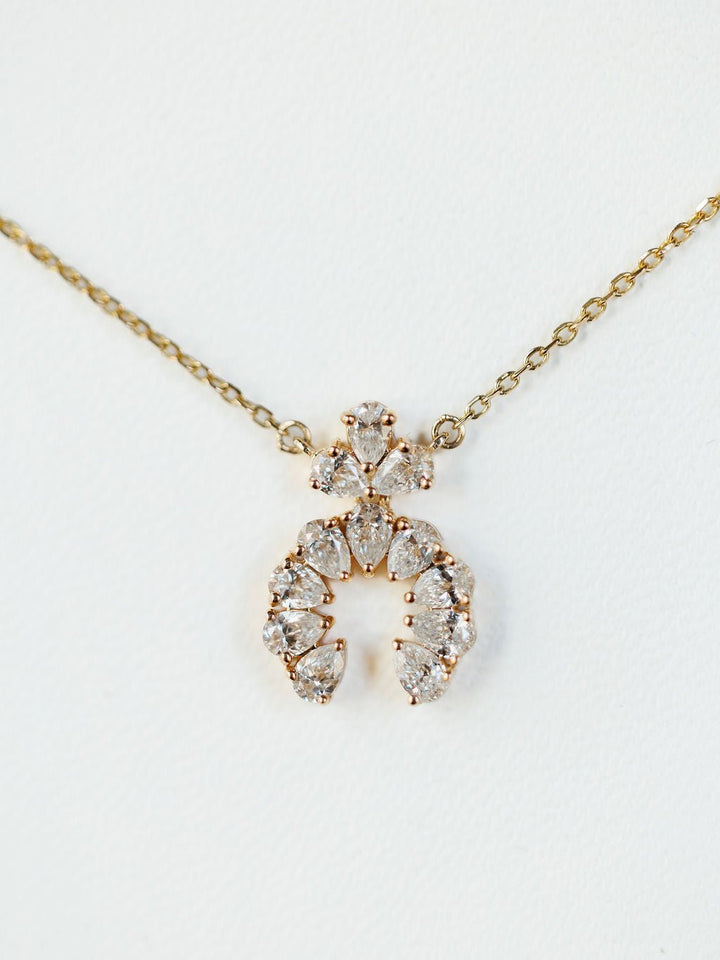 The Diamond Squash Necklace by Savannah Sevens western life{&}style features a 14K gold chain with clear, pear-shaped diamonds in horseshoe and triangular designs, shown against a white background.