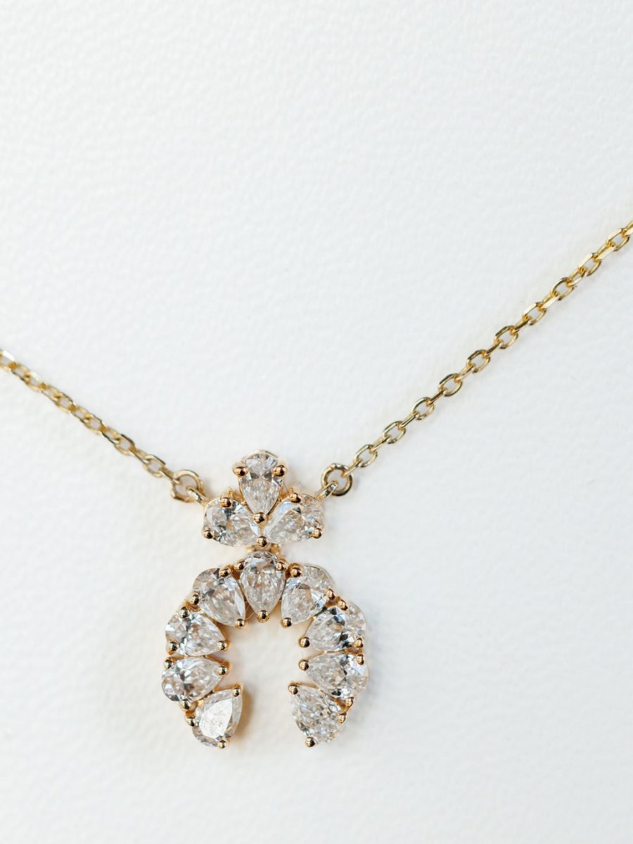 The Diamond Squash Necklace by Savannah Sevens western life{&}style is a 14K gold piece with a semi-circular pendant featuring multiple pear-shaped diamonds, shown against a white background.