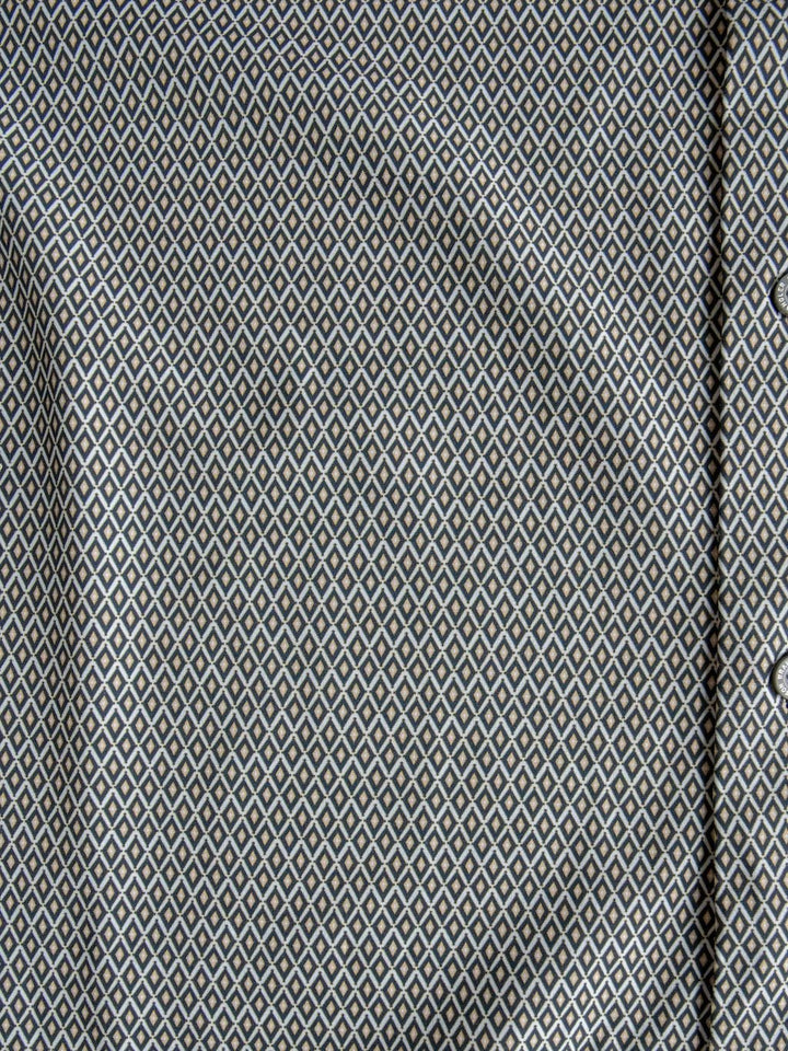 Close-up of the Durham Wrangler Men's Southwest Button Up by Savannah Sevens western life{&}style, showcasing its small, repeating white and blue diamond pattern on a gray background. Visible folds and a portion of the button placket on the right emphasize this shirt’s subtle southwest-inspired style.