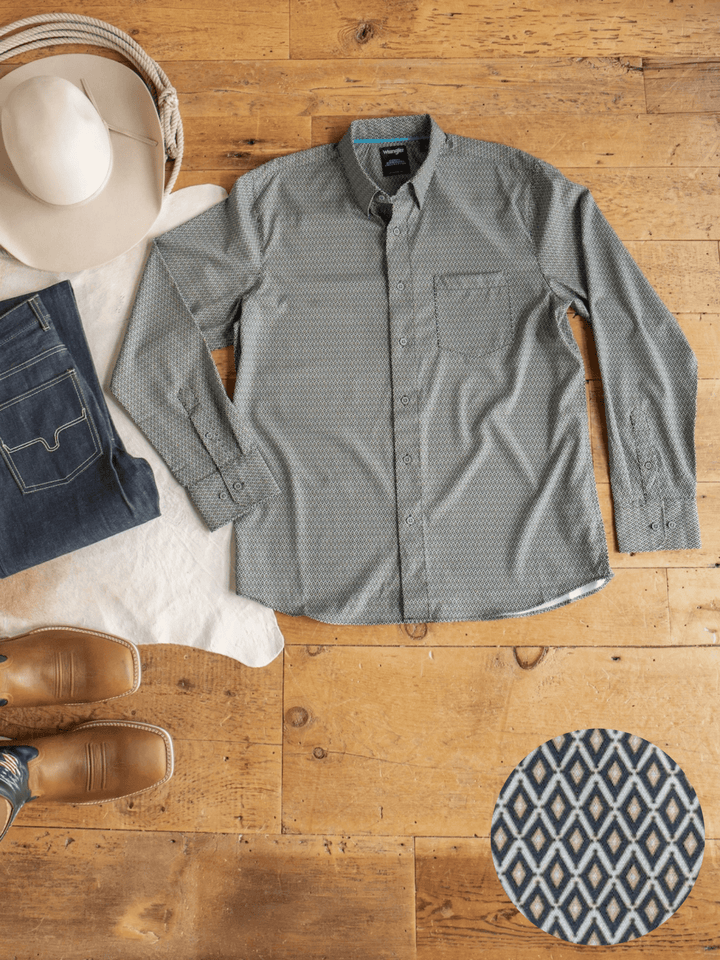 The Durham Wrangler Men's Southwest Button Up from Savannah Sevens western life{&}style is displayed laid flat on a wooden floor, accompanied by a pair of jeans, brown boots, and a cowboy hat. A close-up shot highlights the shirt’s unique diamond-patterned southwest design and its moisture-wicking fabric.