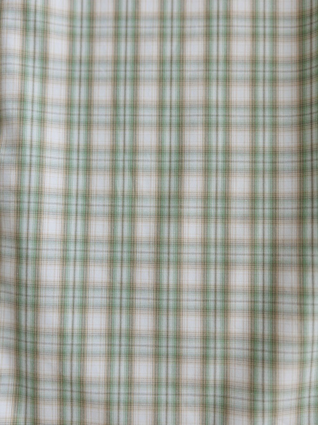 Close-up of fabric with green, white, and light brown plaid pattern from the Eastwood Ariat Men's Plaid Button Up by Savannah Sevens western life{&}style. Evenly spaced checks form a classic grid design.