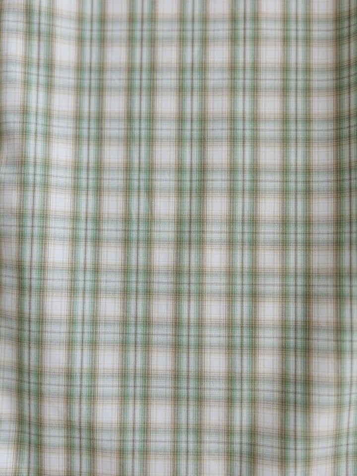 Close-up of fabric with green, white, and light brown plaid pattern from the Eastwood Ariat Men's Plaid Button Up by Savannah Sevens western life{&}style. Evenly spaced checks form a classic grid design.