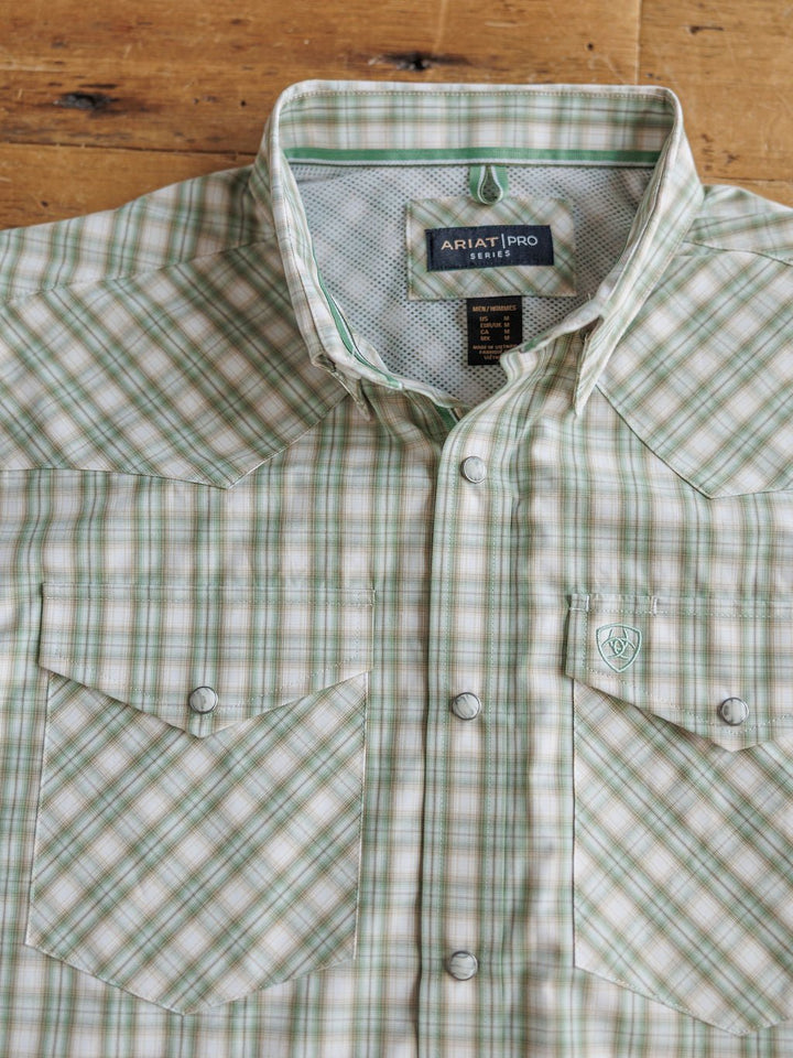 The Eastwood Ariat Men's Plaid Button Up by Savannah Sevens western life{&}style is a light green and beige men’s shirt with front pockets, pearl snap buttons, and a brand label inside the collar—perfect for classic Western style.