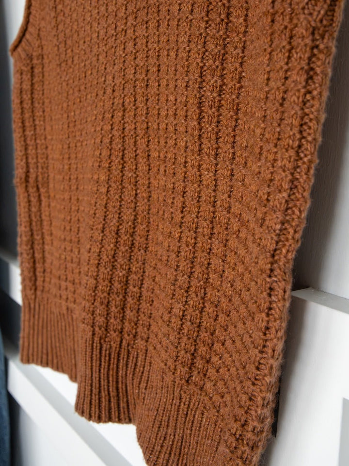A close-up of the Ellaville Sienna Knit Sleeveless Top by Savannah Sevens western life{&}style, featuring a brown textured pattern and scoop neck, displayed on a white surface.