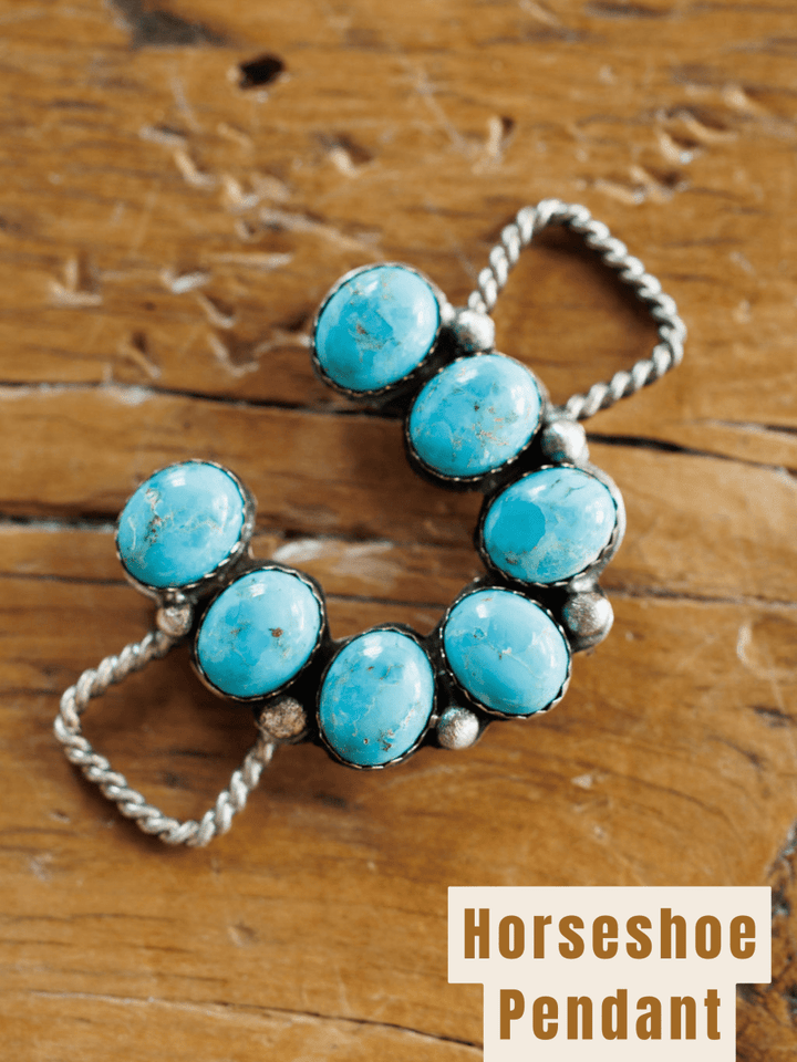 The Etowah Scarf Pendant by Savannah Sevens western life{&}style features seven Kingman turquoise stones set in a sterling silver horseshoe, displayed on rustic wood. "Horseshoe Pendant" is noted in the corner.