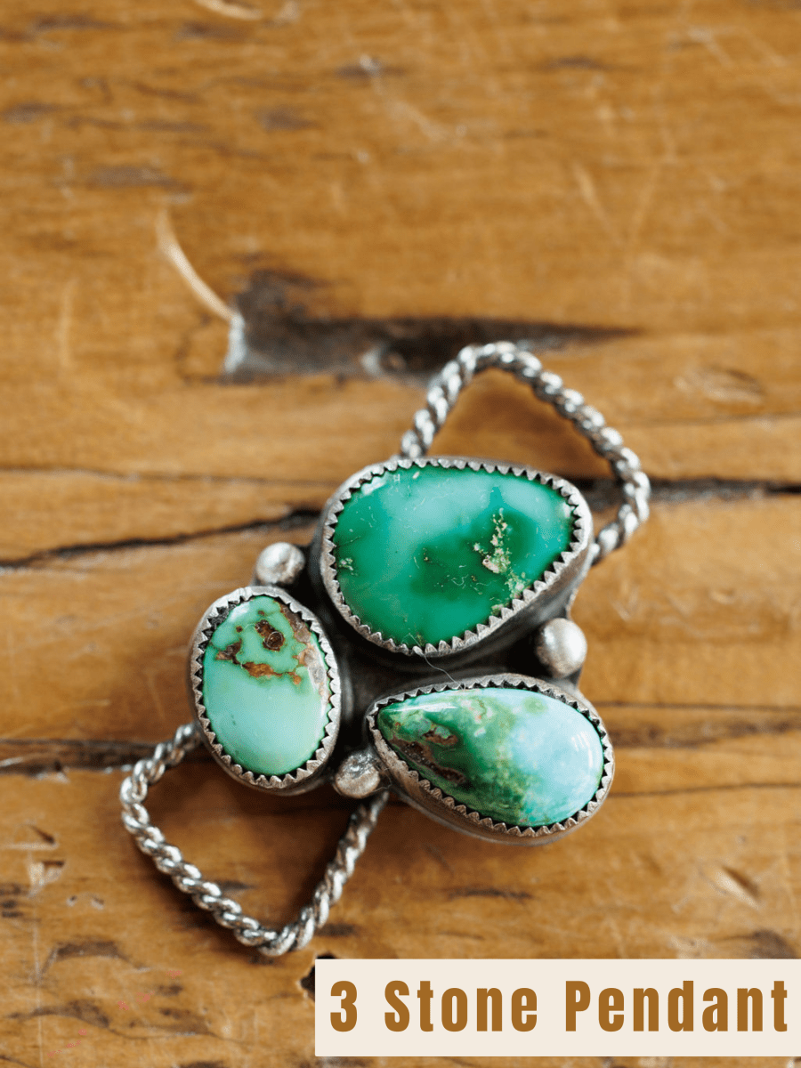 The Etowah Scarf Pendant by Savannah Sevens western life{&}style features three green and Kingman turquoise stones set in sterling silver bezels, shown on a wooden surface. Text at the bottom reads 3 Stone Pendant.