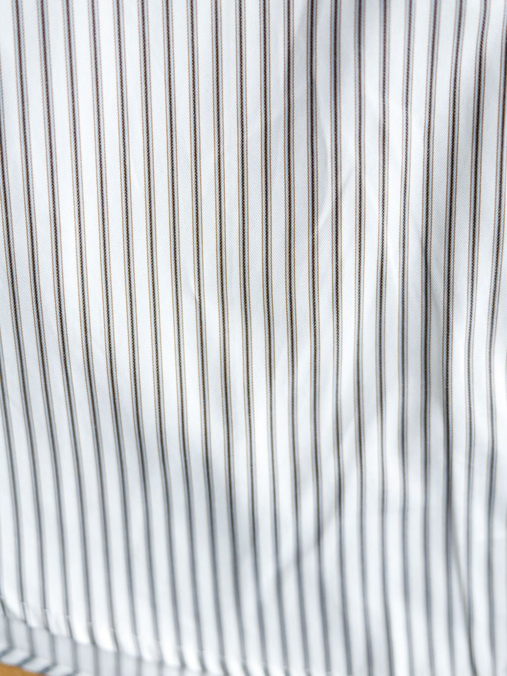 Close-up of The Fordland men's shirt by Savannah Sevens western life&style, featuring evenly spaced thin vertical black stripes and subtle fabric texture that enhances its classic long sleeve button-up style.