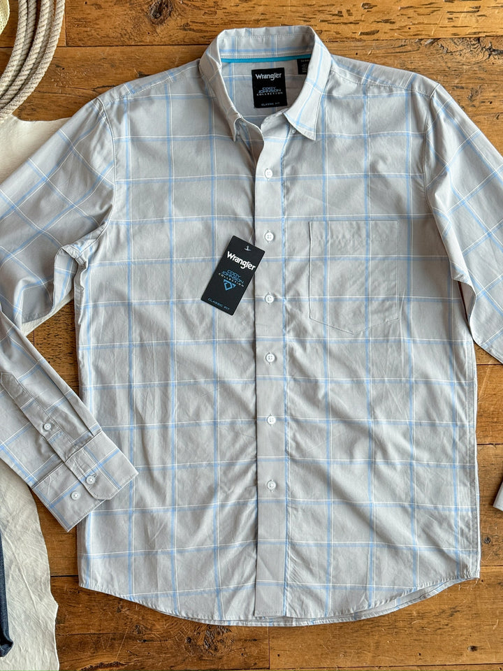 The Garrison men's shirt by Savannah Sevens western life&style is a light gray plaid button-up with blue and white pattern, 100% cotton, front pocket, and a black tag on the top buttonhole, laid flat on a wooden surface.