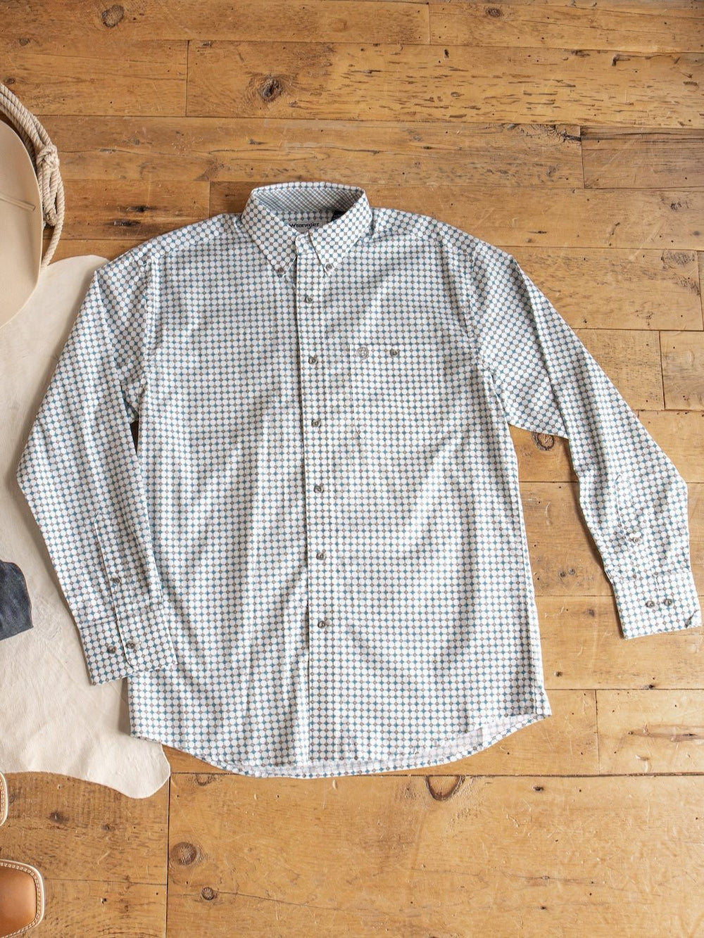 This Georgetown Wrangler Men's Southwest Button Up from Savannah Sevens western life{&}style features a striking blue and green plaid check pattern, a classic collar, and front button closure. Laid flat on a wooden floor, it highlights its timeless style and quality craftsmanship.