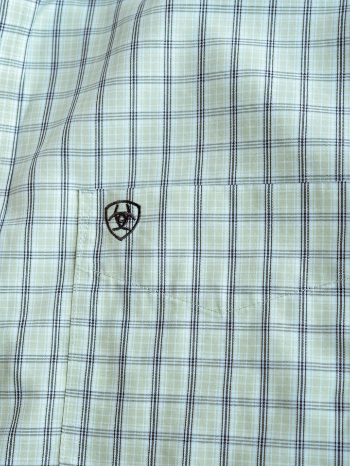 Close-up of the Graham Ariat Men's Plaid Button Up by Savannah Sevens western life{&}style, light green and blue, short sleeves, small front pocket with an embroidered black shield, horseshoe & star emblem. Wrinkle-free fabric for easy care.